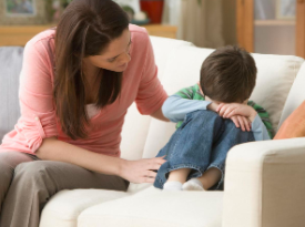 Adult comforting a child on the couch