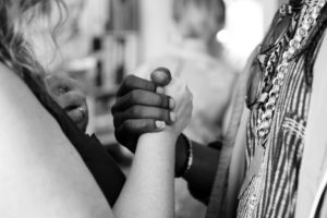 a black and white picture of two people holding hands