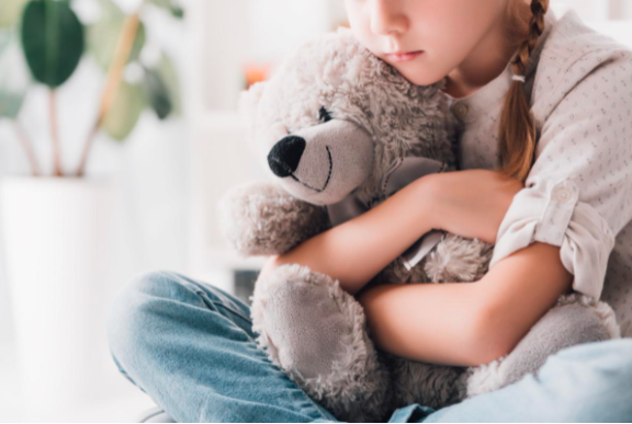 A child holding on to the teddy bear