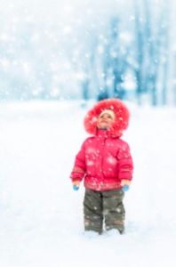 A Child in a snowsuit outside in the snow