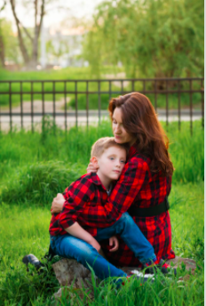 A child sitting on an adult's lap in the field