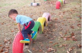 child climbing on tires in playground