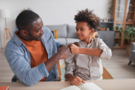 a child and an adult doing a handshake