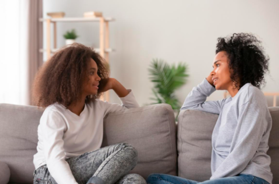 dult and teenager on the couch smiling at one another