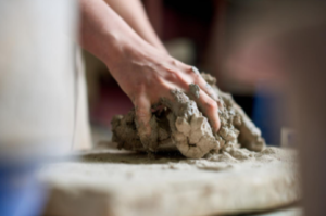 two hands kneading the clay