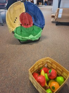 A basket of fruits and a bean bag catch basket with holes